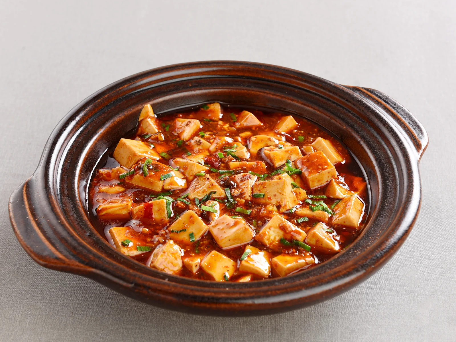 Mapo tofu served in a dark clay casserole